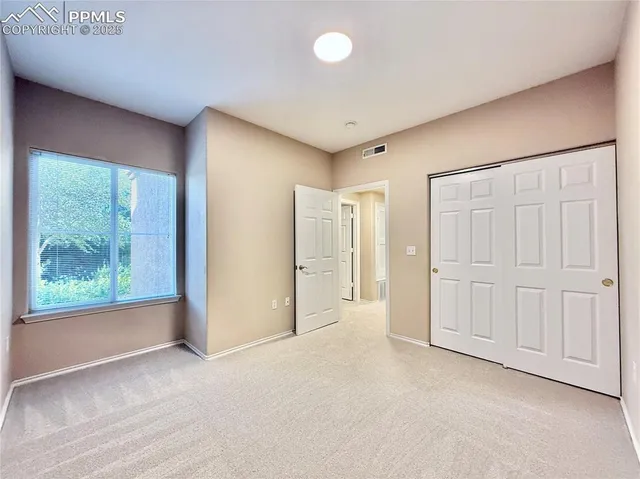 an empty room with windows and closet
