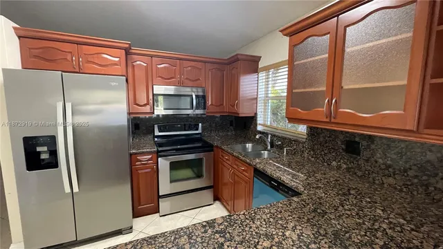 a kitchen with stainless steel appliances granite countertop a stove a refrigerator and a sink