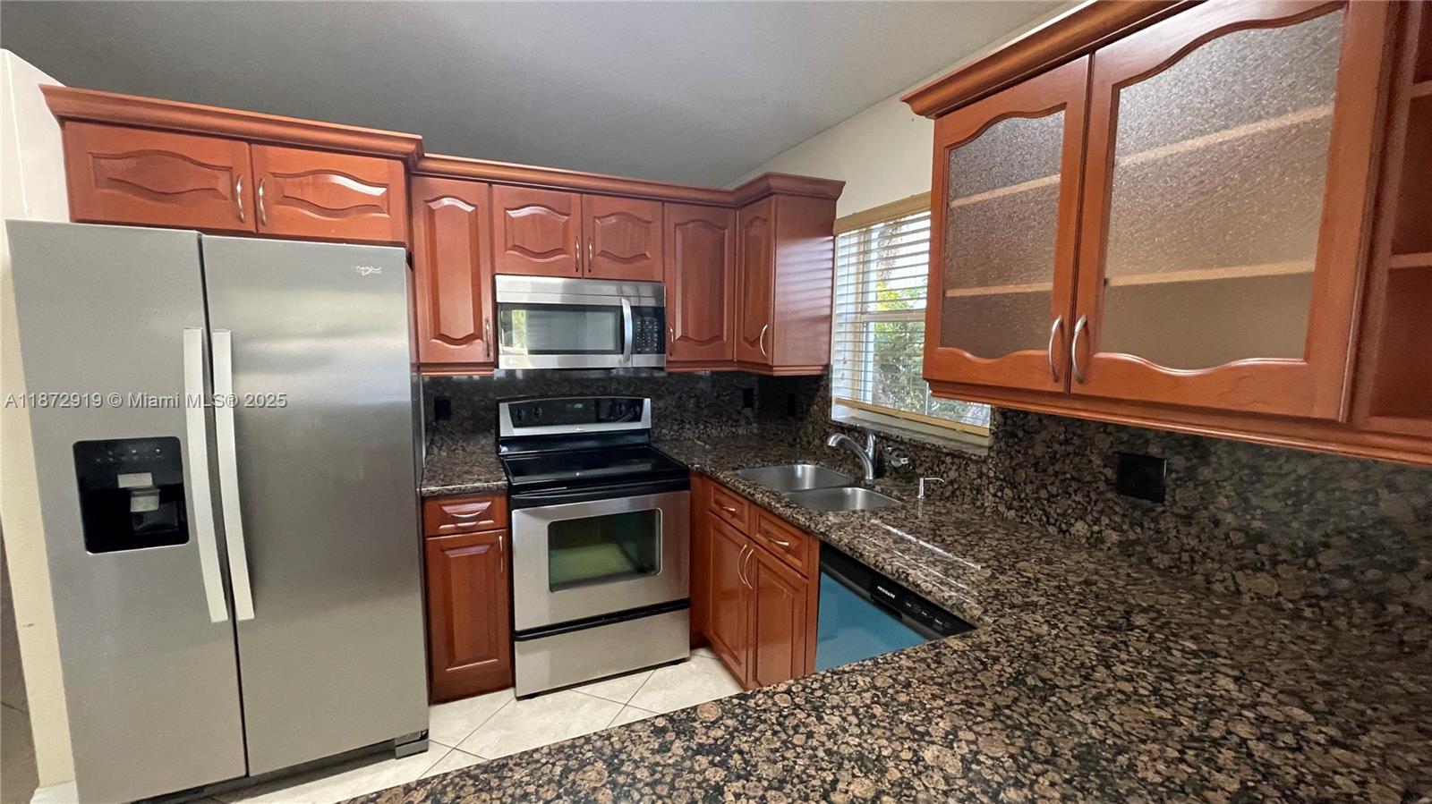 a kitchen with stainless steel appliances granite countertop a stove a refrigerator and a sink