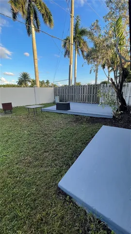 a view of an house with backyard and sitting area