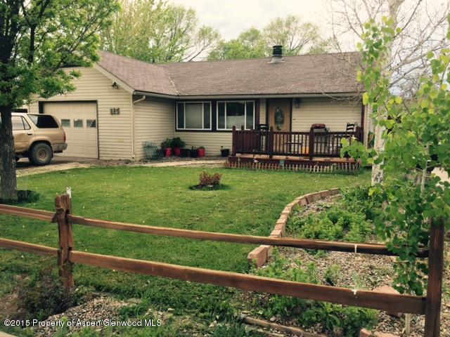 115 Will Avenue Rifle, CO 81650 - Photo 1 of 4 a front view of a house with a yard table and chairs