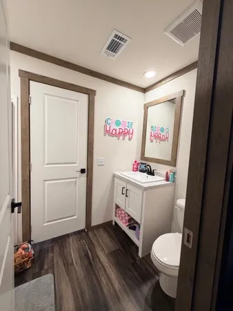 a bathroom with a sink a toilet and a mirror