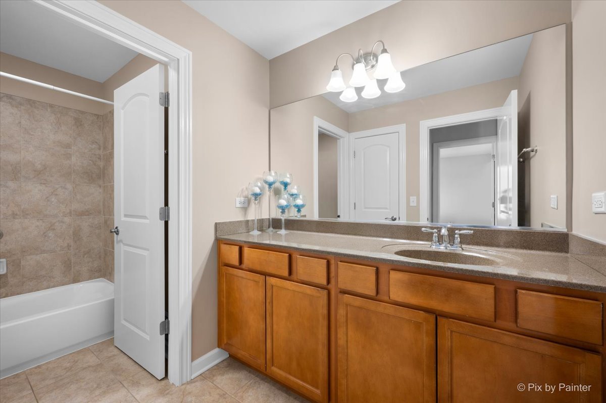 4375 Rudyard Kipling Road Elgin, IL 60124 - Photo 25 of 33 a bathroom with a granite countertop sink a large mirror and a bathtub