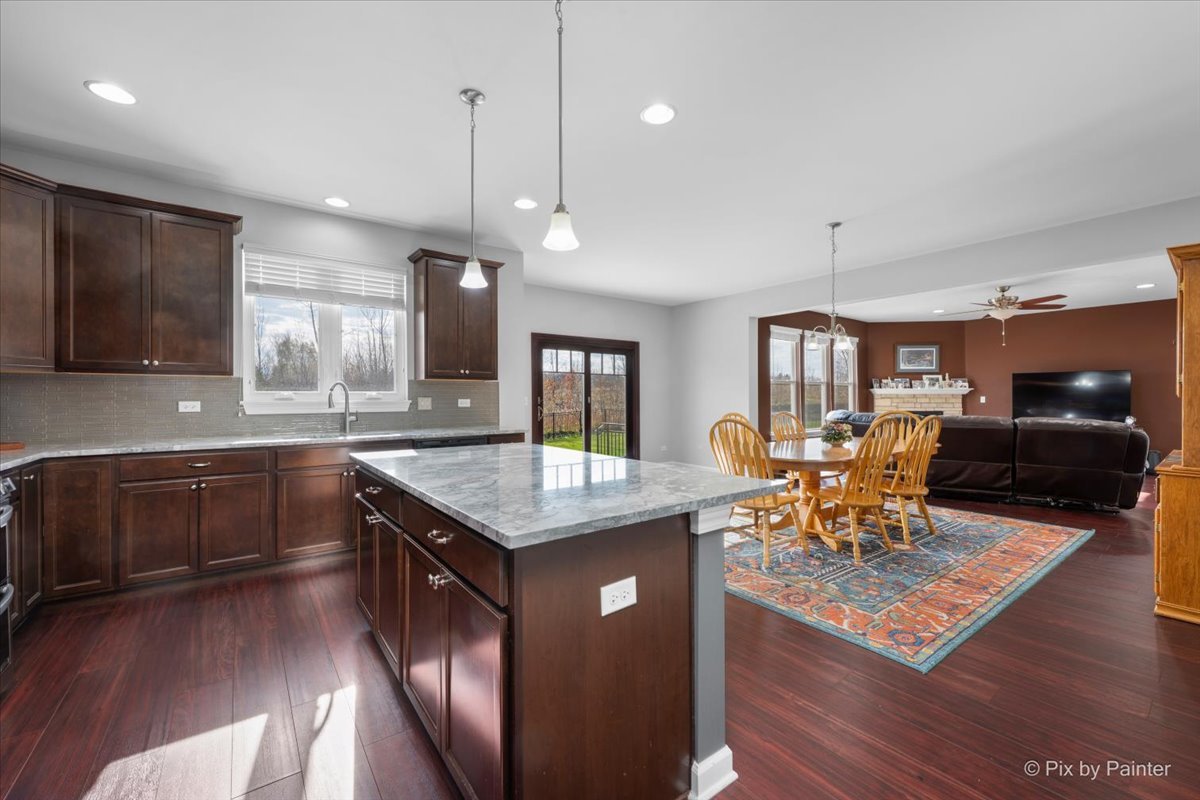 4375 Rudyard Kipling Road Elgin, IL 60124 - Photo 8 of 33 a kitchen with stainless steel appliances granite countertop a table chairs and a refrigerator