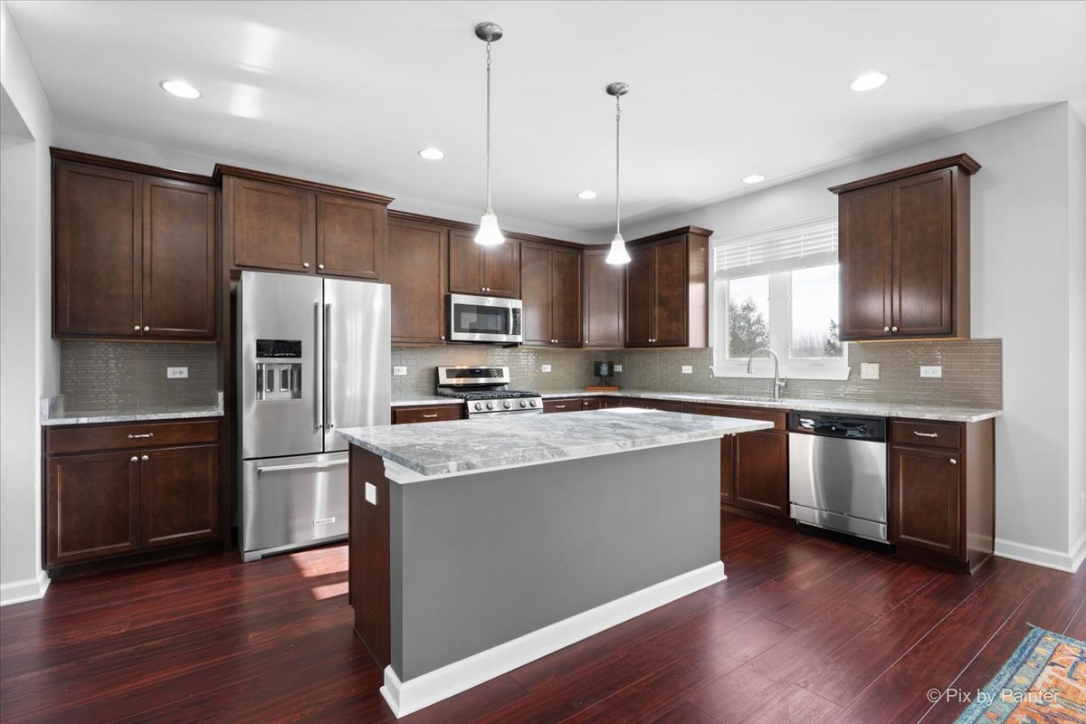4375 Rudyard Kipling Road Elgin, IL 60124 - Photo 9 of 33 a kitchen with stainless steel appliances granite countertop a refrigerator a sink dishwasher a stove and white cabinets with wooden floor