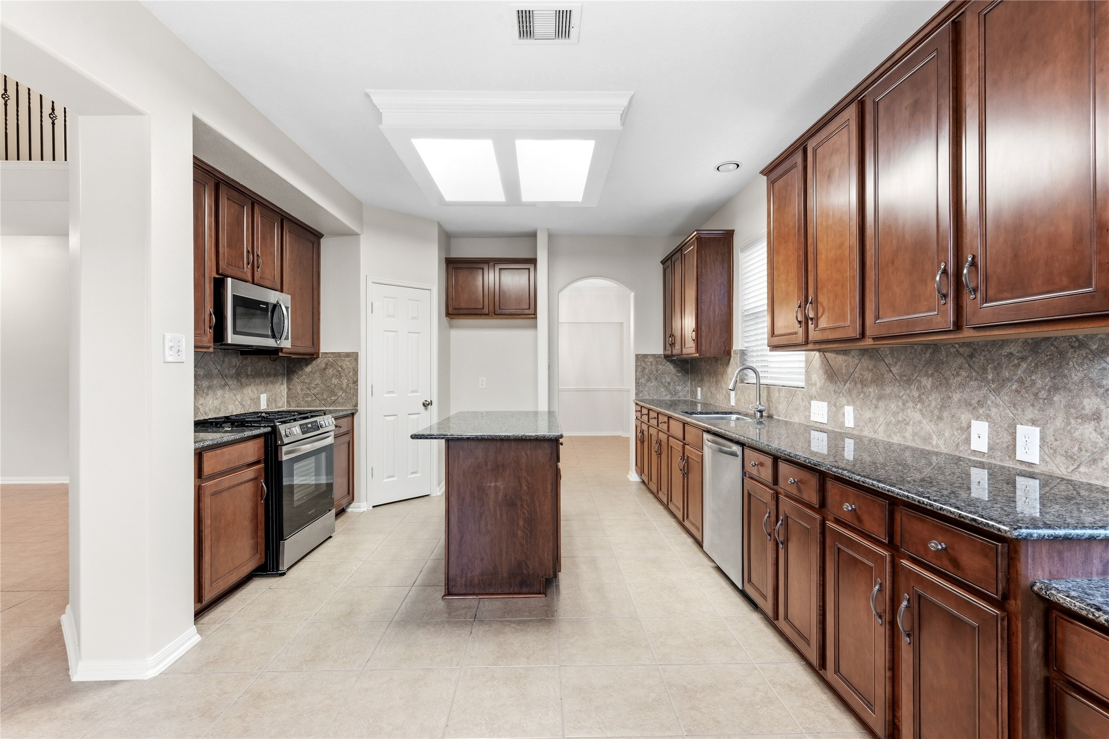 6211 Stone Hill Road Spring, TX 77389 - Photo 12 of 43 a large kitchen with stainless steel appliances granite countertop a stove top oven a sink dishwasher a refrigerator and cabinets with wooden floor