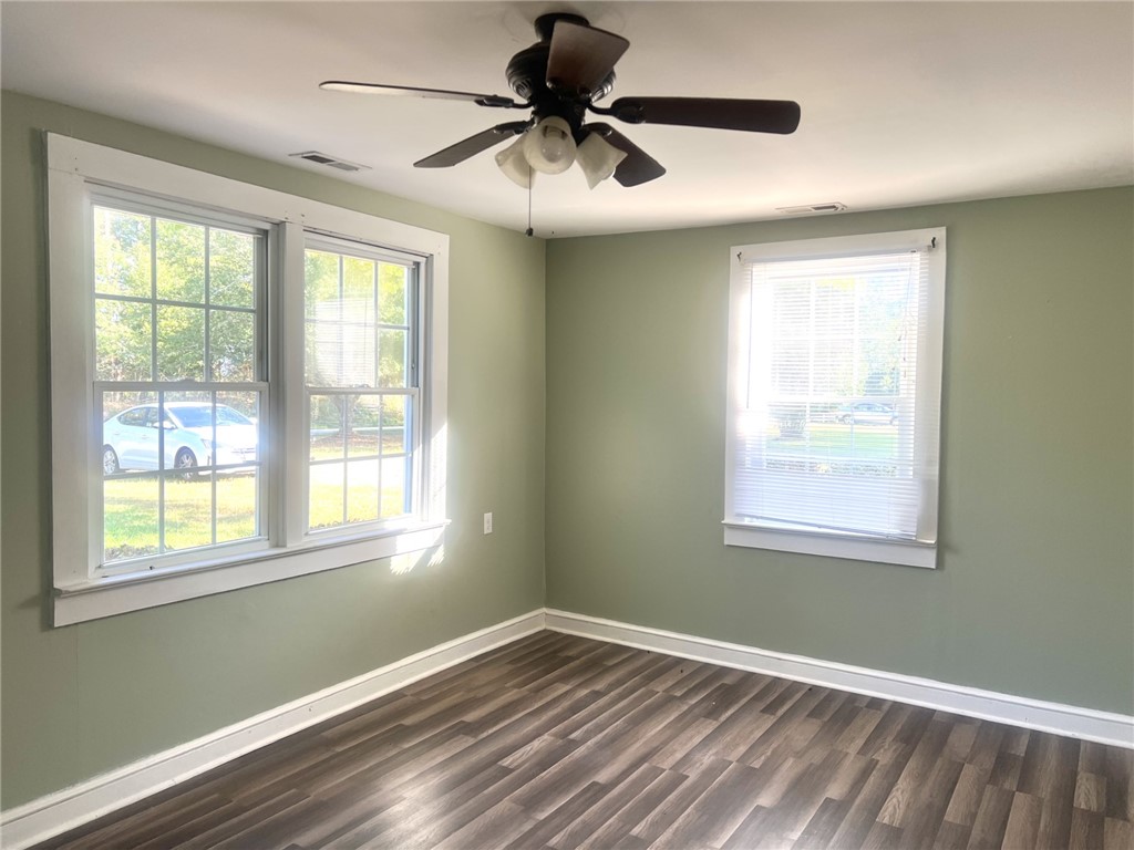 252 Friendship Road Seneca, SC 29678 - Photo 4 of 11 Double-hung windows draw natural light across the polished wood-look flooring of this versatile room.