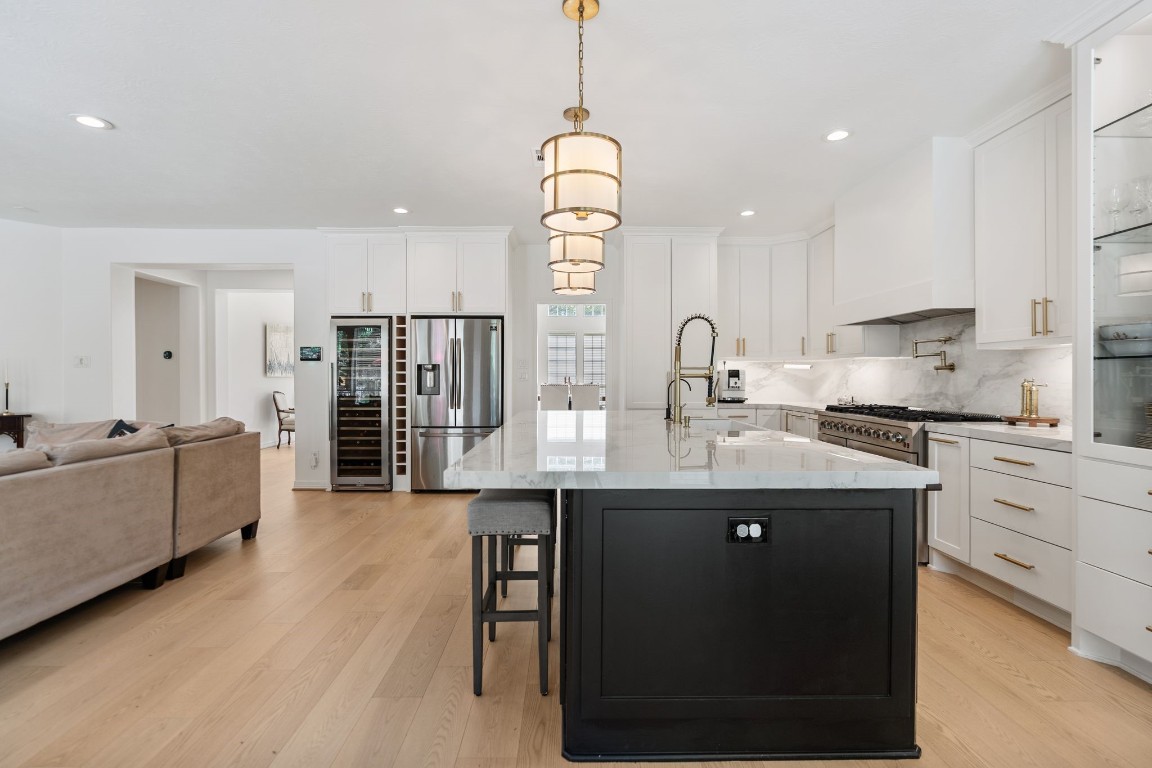 5515 Chase Harbor Houston, TX 77041 - Photo 14 of 48 Thoughtfully redesigned and beautifully open, the kitchen balances statement style with everyday function through custom cabinetry, oversized island seating, and seamless connection to the living spaces.