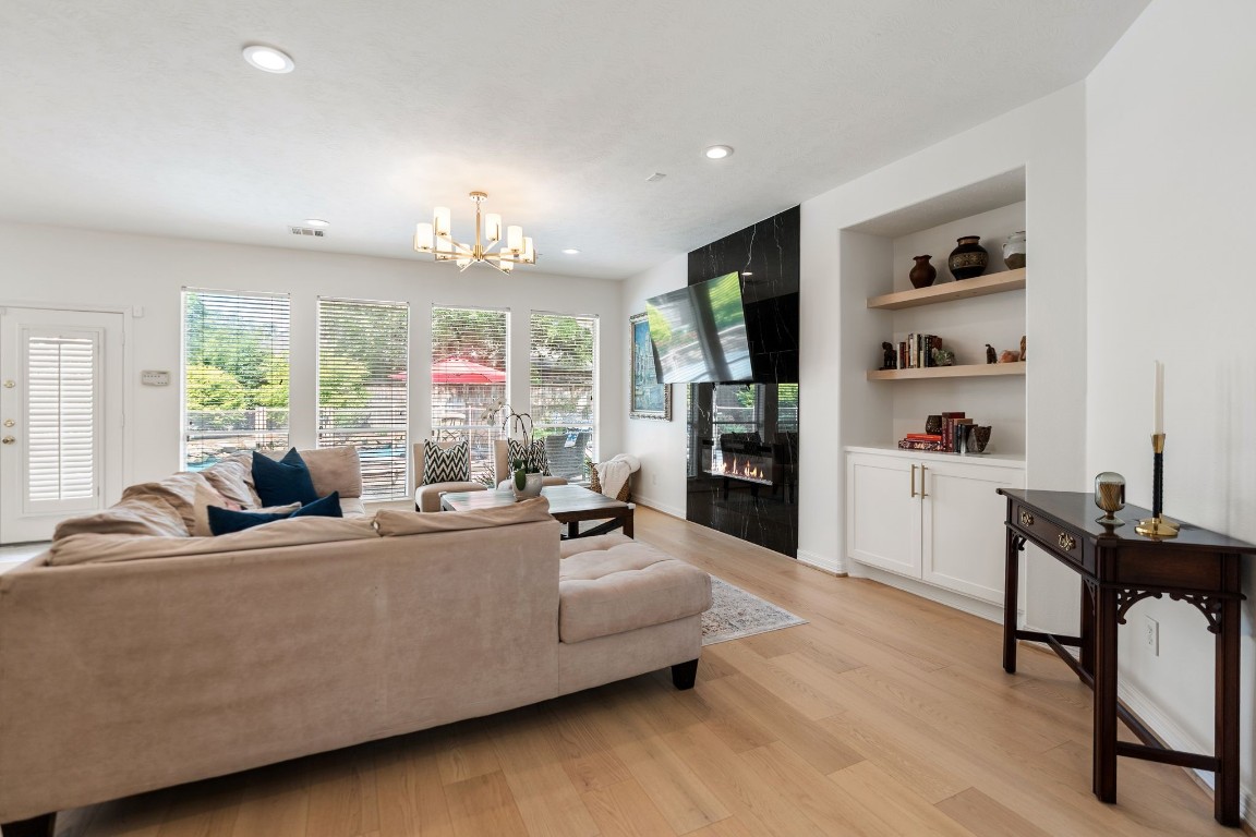 5515 Chase Harbor Houston, TX 77041 - Photo 16 of 48 The Great Room offers generous scale, easy flow, and a warm modern feel with wide plank flooring and built-in display shelving.