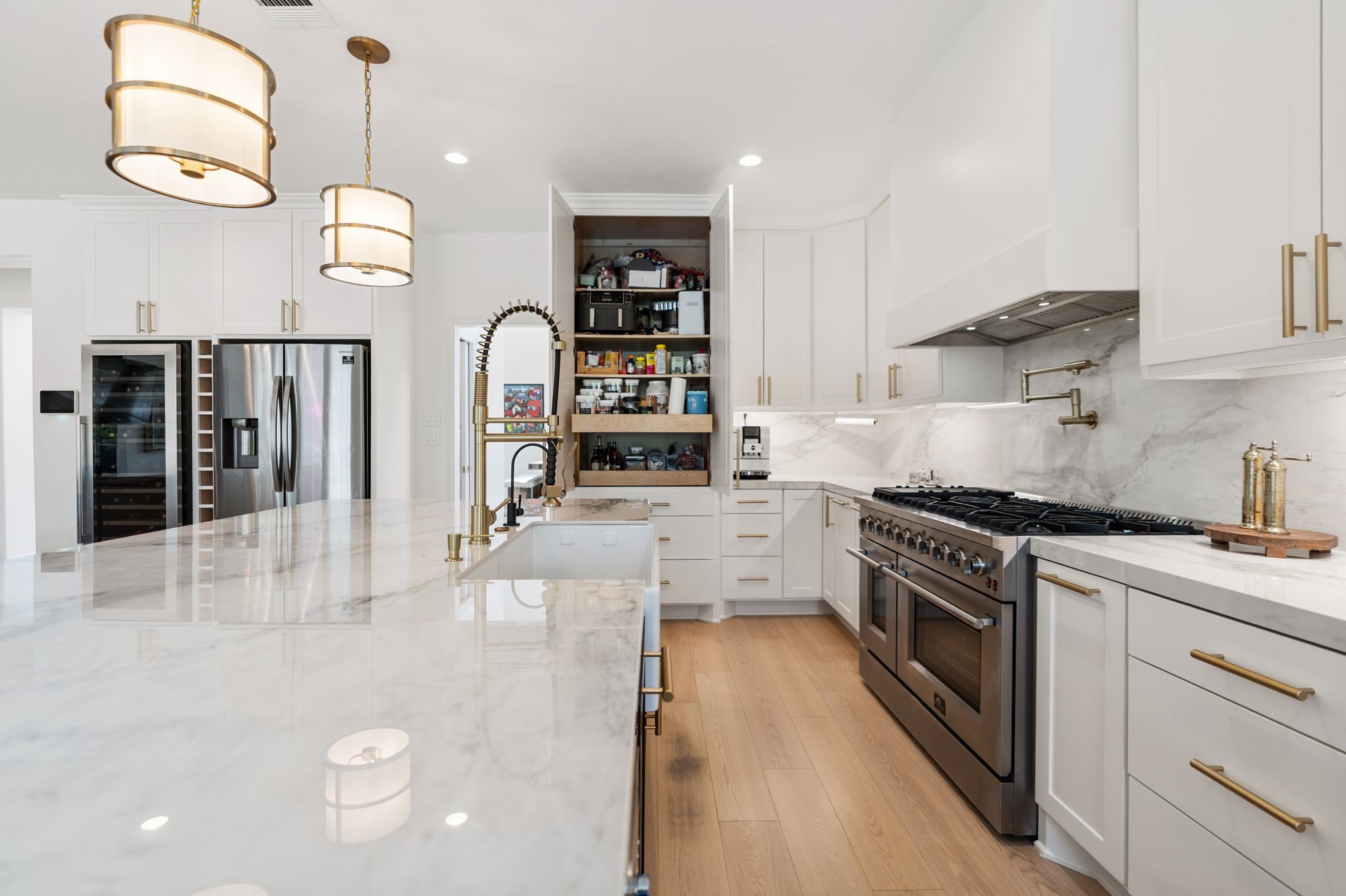 5515 Chase Harbor Houston, TX 77041 - Photo 2 of 48 A professional-style 8 burner gas range, pot filler, striking vent hood, and slab backsplash create a dramatic focal point in this chef-inspired kitchen.