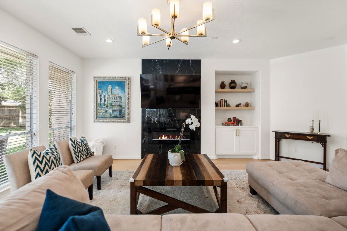 5515 Chase Harbor Houston, TX 77041 - Photo 5 of 48 Expansive and open, the main living area features wide plank flooring and a porcelain slab fireplace surround that adds modern sophistication. Designed for both entertaining and everyday comfort.