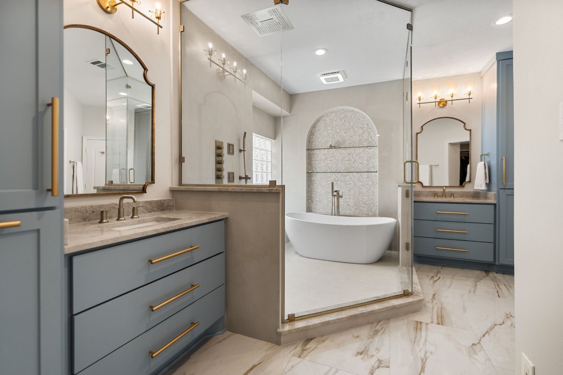 5515 Chase Harbor Houston, TX 77041 - Photo 8 of 48 A boutique hotel experience at home. The freestanding soaking tub sits within a glass enclosure beneath an architectural arched niche with glass shelving. Large format Porcelain tile floors and warm brass fixtures complete the serene retreat.