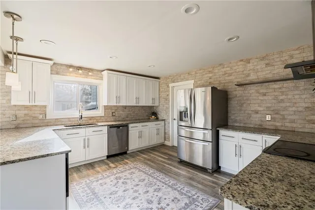 a kitchen with granite countertop stainless steel appliances a sink and a counter space