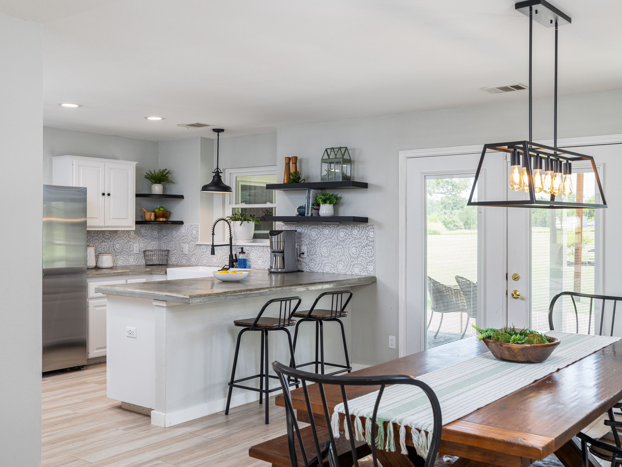 3001 County Road 255 Georgetown, TX 78633 - Photo 12 of 35 A well-lit kitchen with a spacious island flows seamlessly into a dining area, offering direct access to the outdoors.