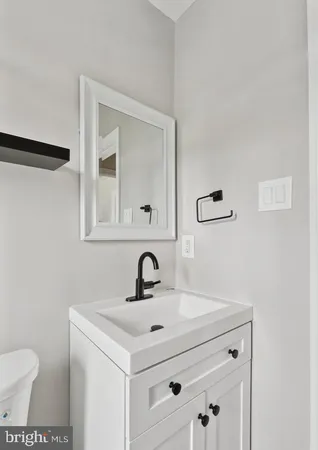a bathroom with a sink toilet and mirror