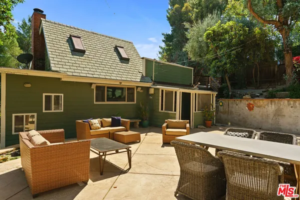 a backyard of a house with fire pit and outdoor seating