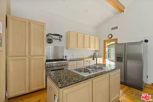 a kitchen with stainless steel appliances granite countertop a sink stove and refrigerator