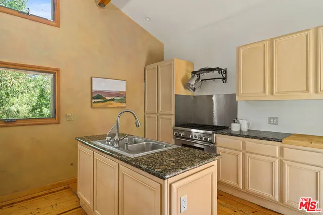 a kitchen with stainless steel appliances granite countertop a stove sink and cabinets