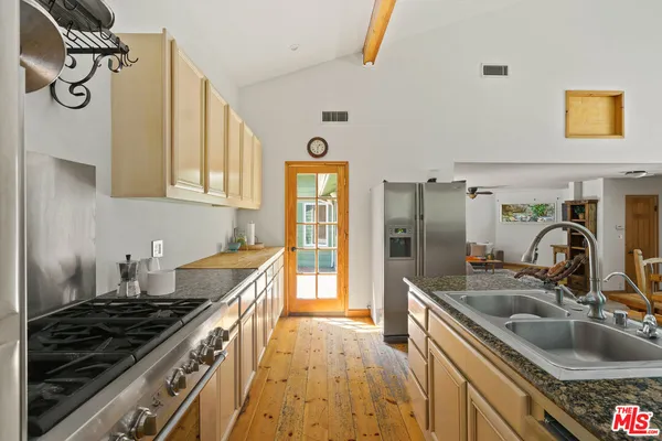 a kitchen with granite countertop a sink stove and refrigerator