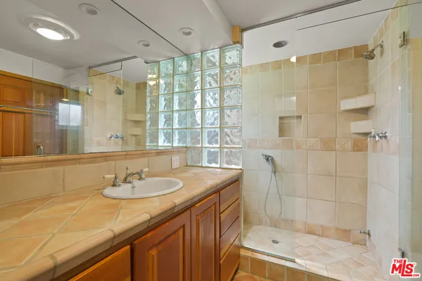 a bathroom with a granite countertop sink a shower and a mirror