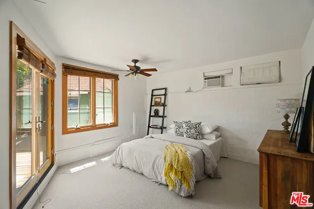 a bedroom with a bed and a flat tv screen on the dresser