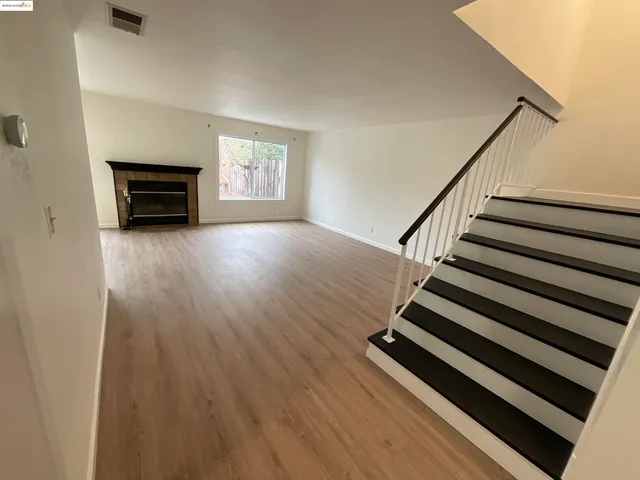 a view of a livingroom with wooden floor and a ceiling fan