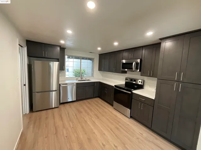 a large kitchen with stainless steel appliances granite countertop a refrigerator sink and cabinets