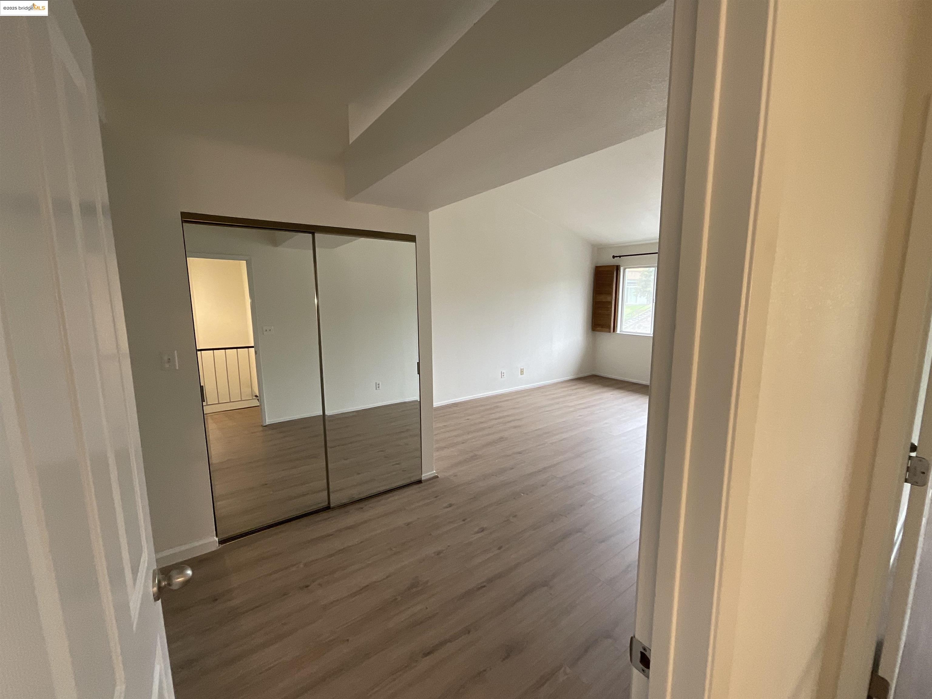 131 Pelican Loop Pittsburg, CA 94565 - Photo 7 of 16 an empty room with wooden floor and mirror
