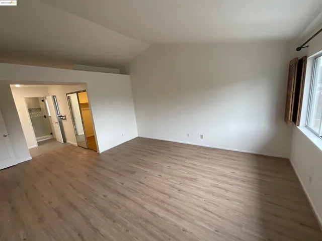 an empty room with wooden floor and window