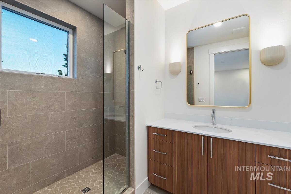 3213 West Moore Street Boise, ID 83702 - Photo 25 of 32 Modern bathroom featuring a glass-enclosed shower with large format wall tiles and hexagonal floor tiles
