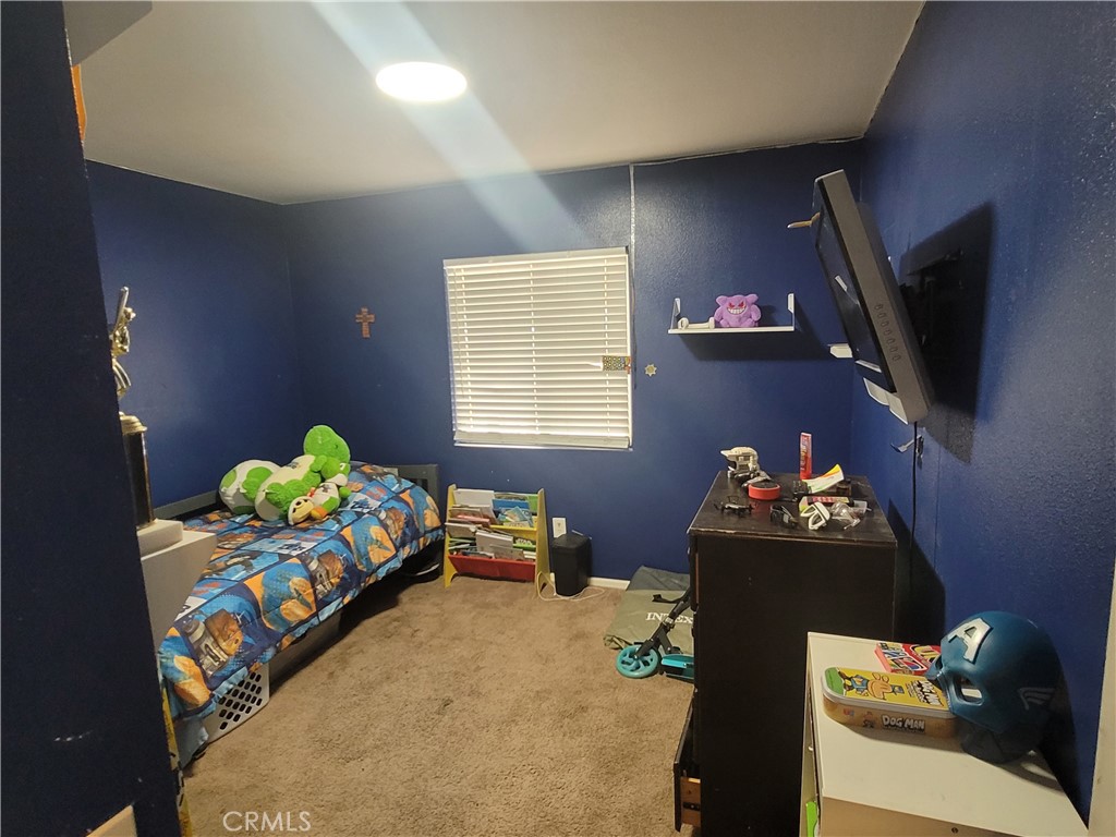 11930 Poppy Road Adelanto, CA 92301 - Photo 20 of 22 a bedroom with bed and a couch