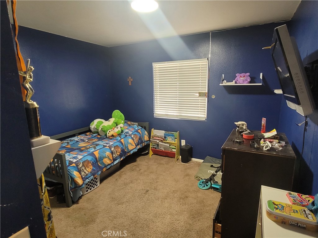 11930 Poppy Road Adelanto, CA 92301 - Photo 21 of 22 a bedroom with a bed and a window