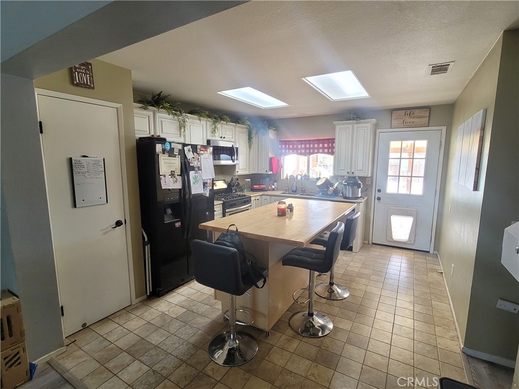 11930 Poppy Road Adelanto, CA 92301 - Photo 7 of 22 a large kitchen with a table and chairs