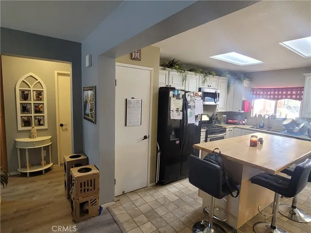 a kitchen with a refrigerator a stove and a dining table with wooden cabinet