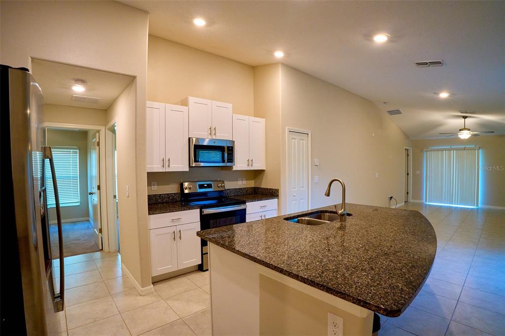 13351 Willow Bluestar Loop Riverview, FL 33579 - Photo 4 of 15 a kitchen with stainless steel appliances granite countertop a sink refrigerator and cabinets