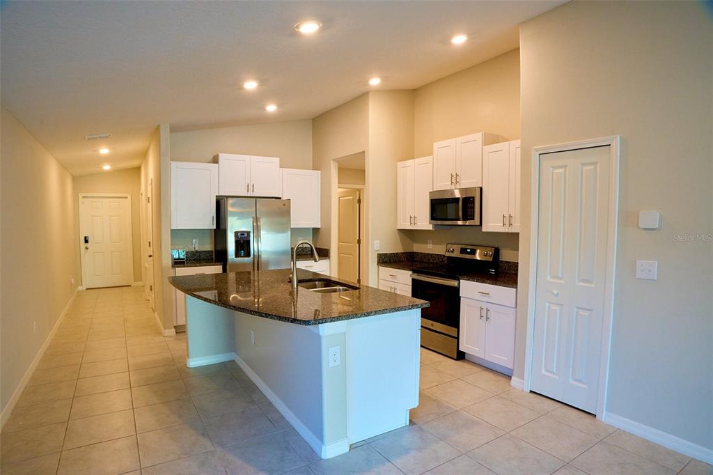 13351 Willow Bluestar Loop Riverview, FL 33579 - Photo 5 of 15 a kitchen with stainless steel appliances granite countertop a sink and a stove