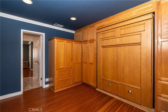 an empty room with wooden floor and closet