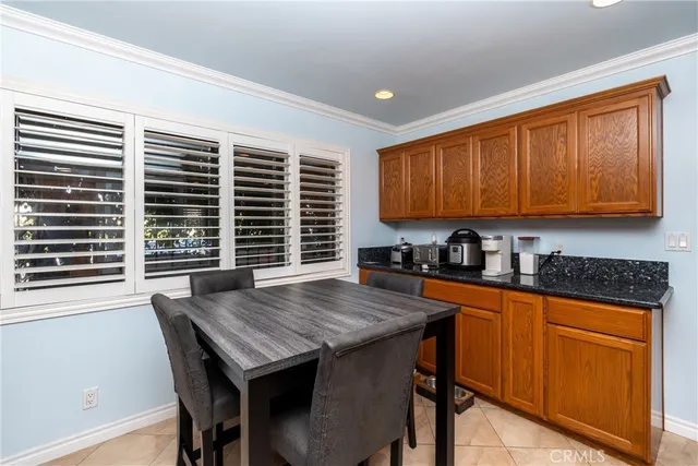 a kitchen with granite countertop wooden cabinets dining table and chairs