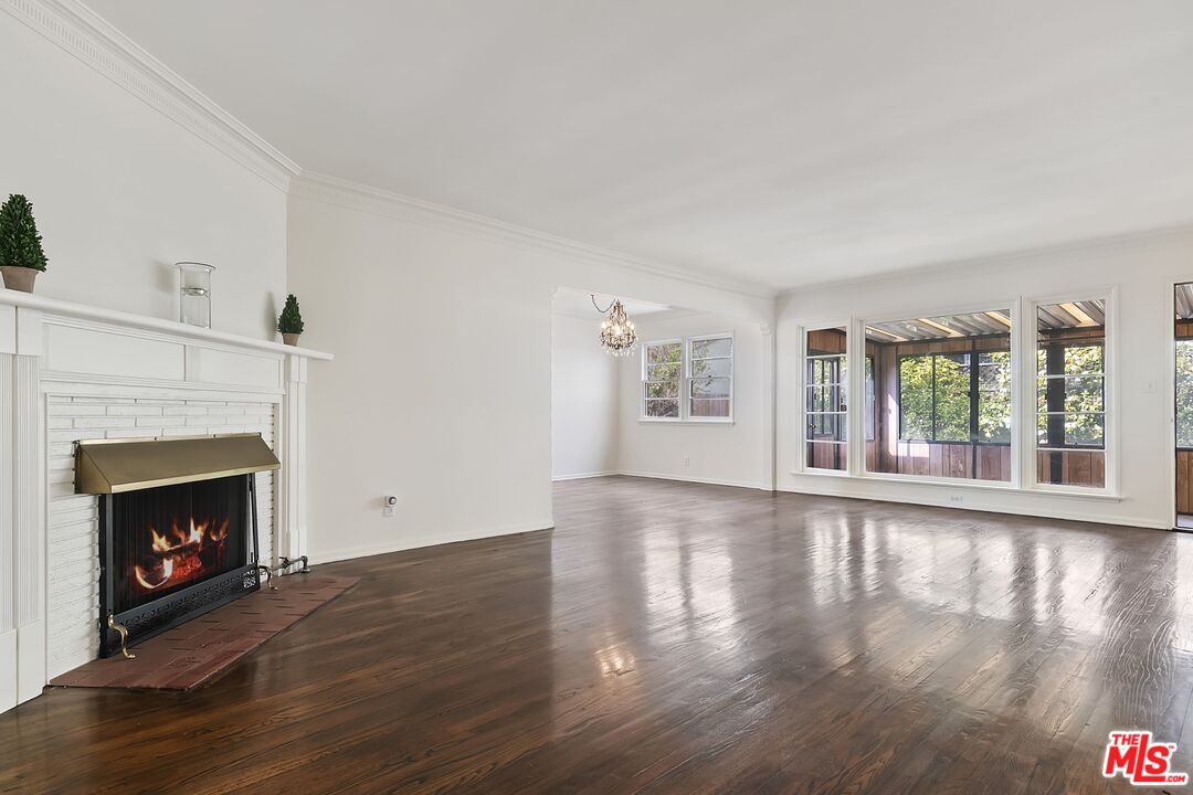 11357 Gladwin Street Los Angeles, CA 90049 - Photo 2 of 15 a view of an empty room with wooden floor fireplace and a window