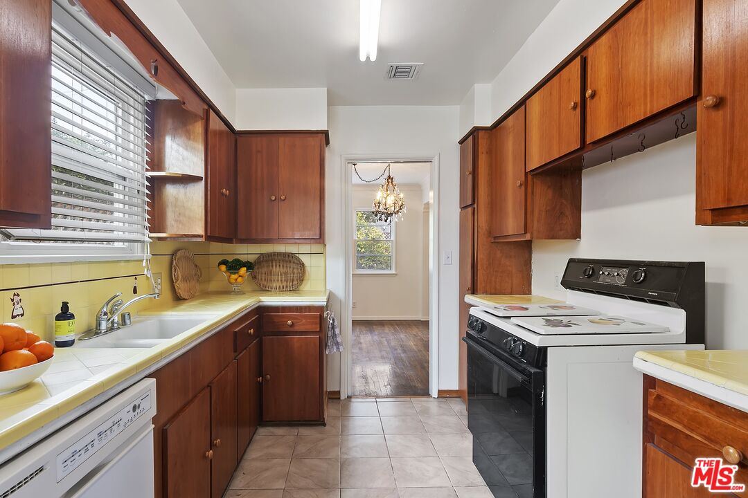 11357 Gladwin Street Los Angeles, CA 90049 - Photo 6 of 15 a kitchen with stainless steel appliances granite countertop a sink a stove and a refrigerator
