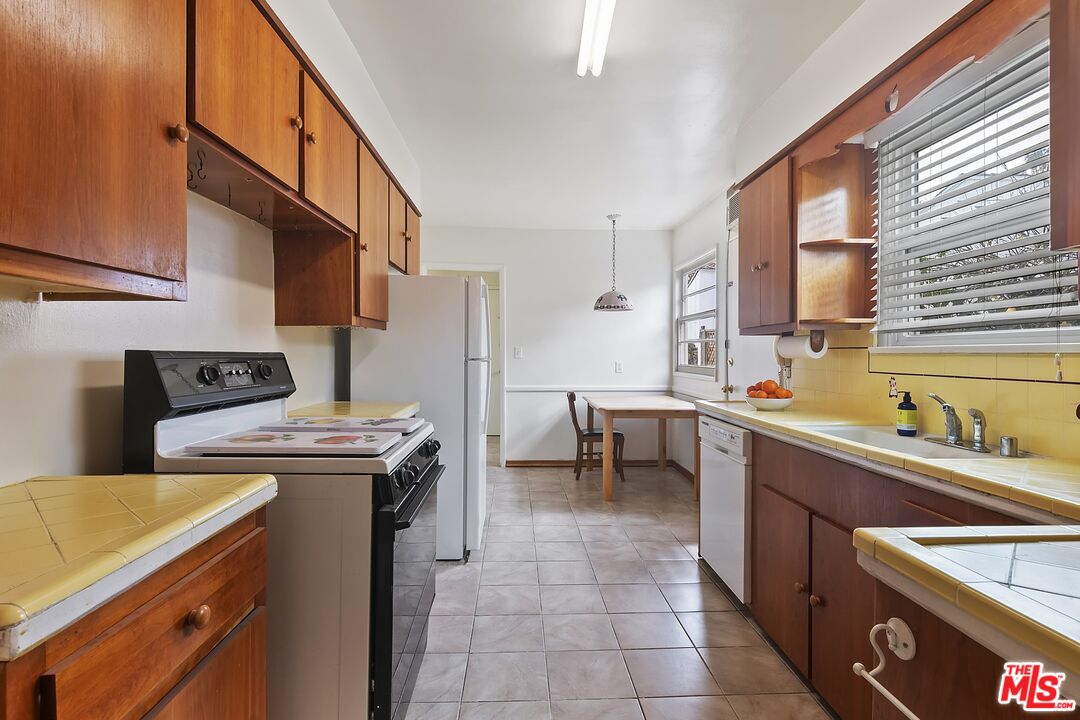 11357 Gladwin Street Los Angeles, CA 90049 - Photo 8 of 15 a kitchen with a stove a sink and a refrigerator