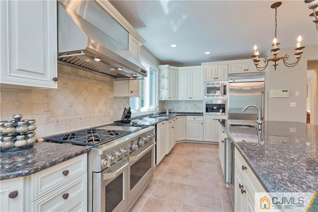 92 Union Valley Road Monroe Township, NJ 08831 - Photo 9 of 23 a kitchen with granite countertop a stove a sink dishwasher a refrigerator and white cabinets with wooden floor