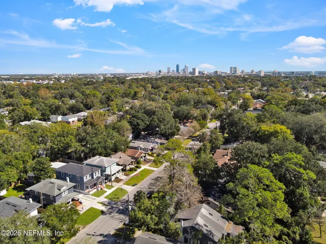 a view of backyard of house with wooden fence
