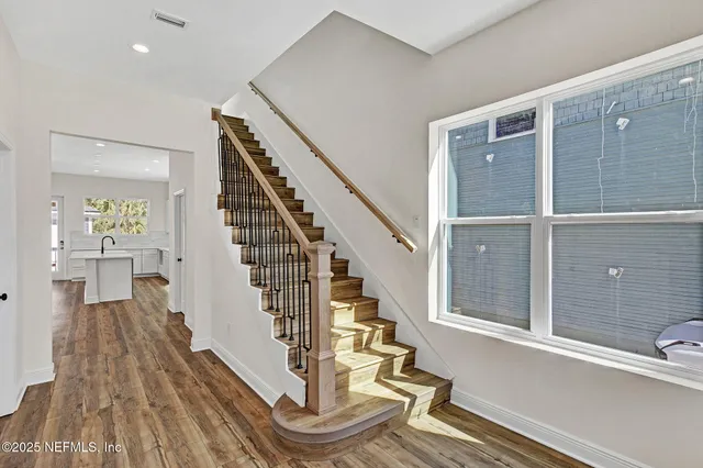 a view of a bathroom with bathtub wooden floor and windows