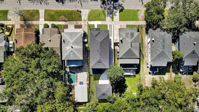 an aerial view of residential houses with outdoor space and parking