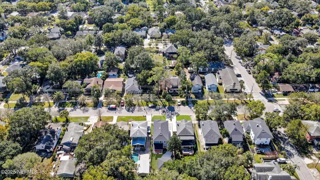 an aerial view of residential houses with outdoor space and swimming pool