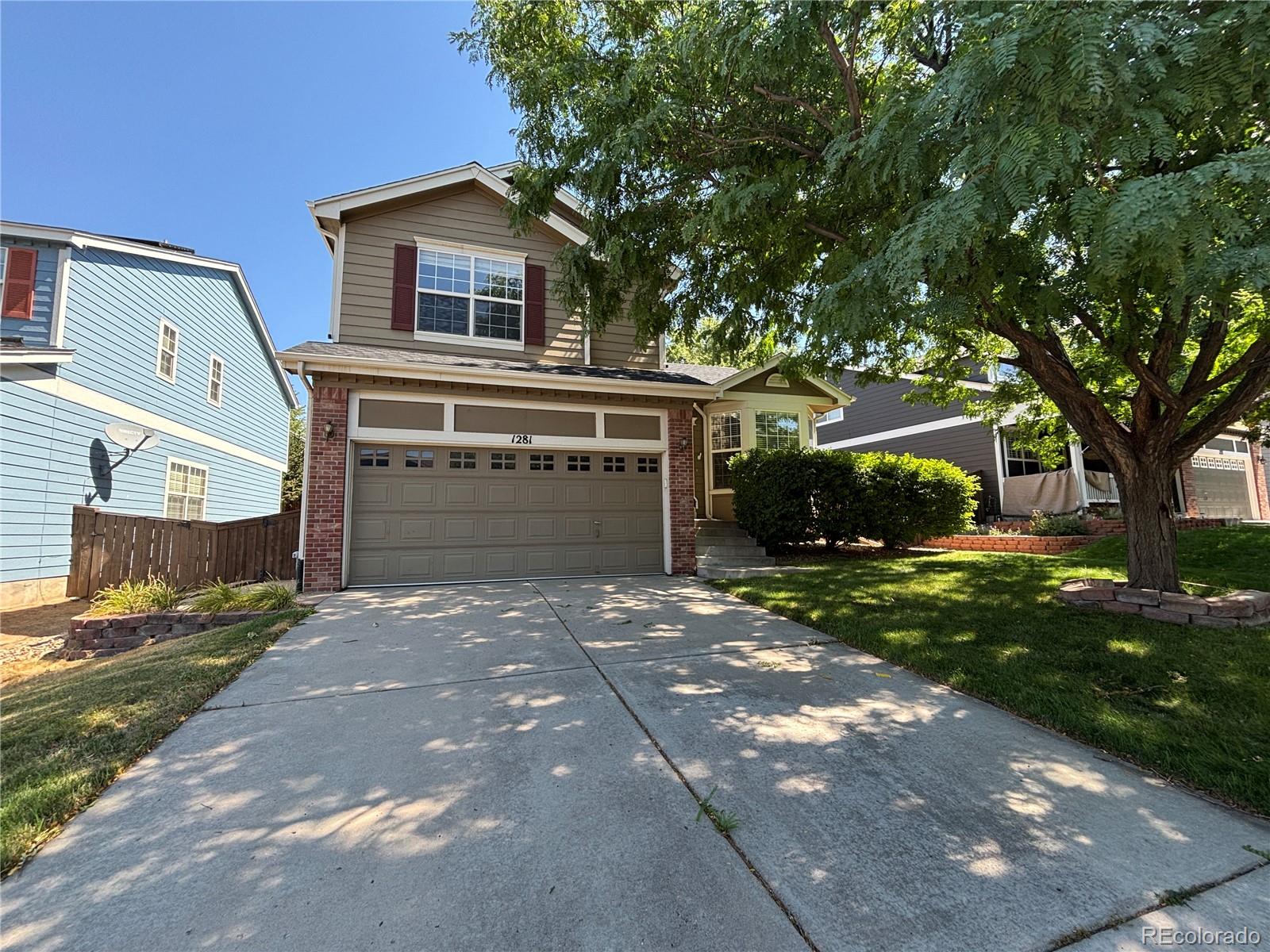 1281 Riddlewood Road Highlands Ranch, CO 80129 - Photo 1 of 27 a front view of a house with a garden and trees