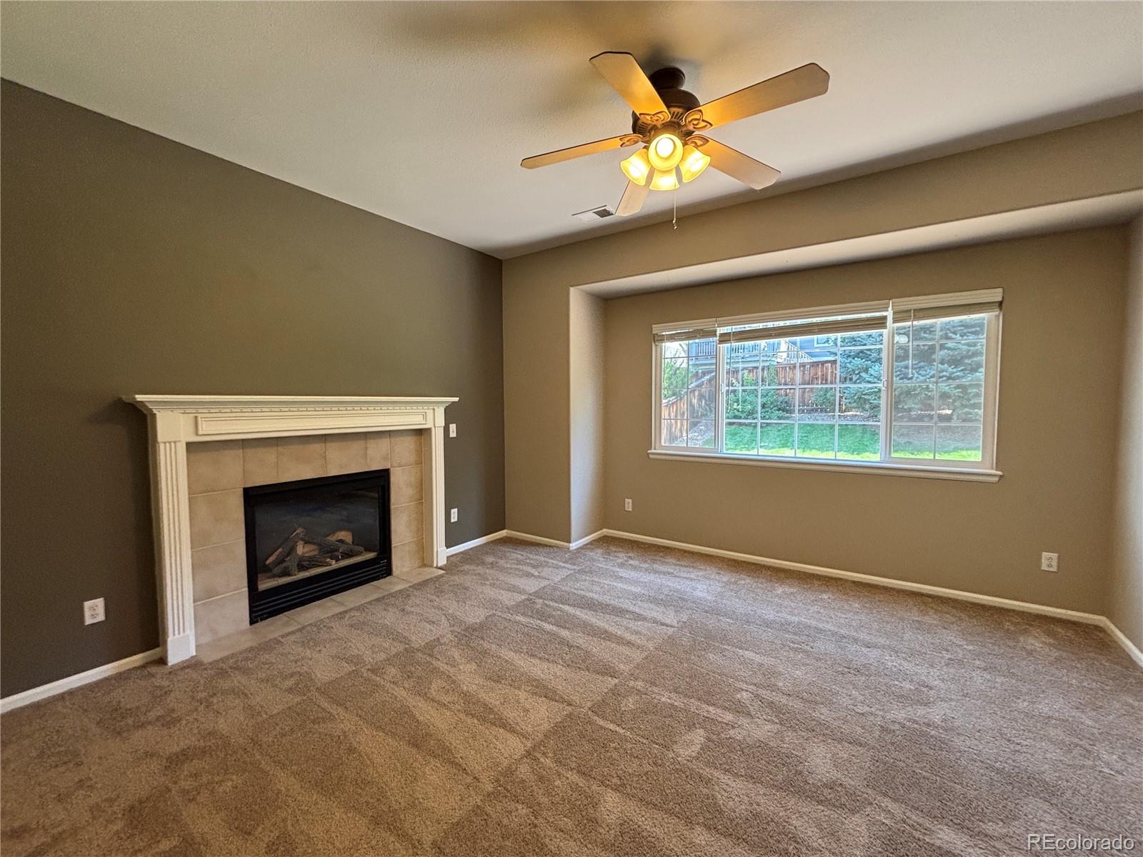 1281 Riddlewood Road Highlands Ranch, CO 80129 - Photo 12 of 27 a view of an empty room with a fireplace and a window