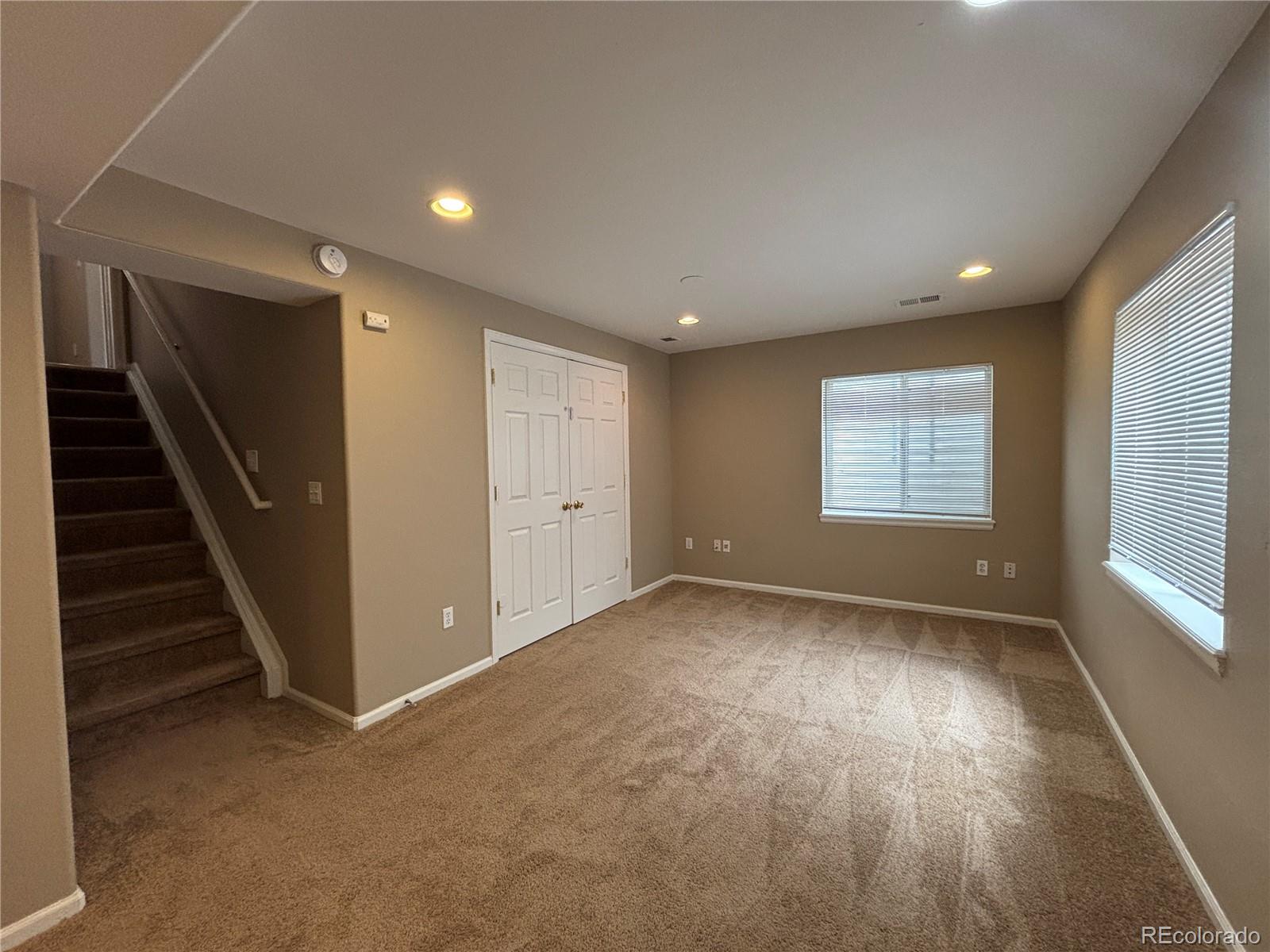 1281 Riddlewood Road Highlands Ranch, CO 80129 - Photo 22 of 27 a view of an empty room with wooden floor and stairs