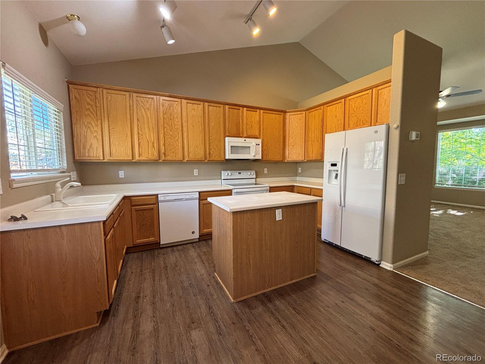 1281 Riddlewood Road Highlands Ranch, CO 80129 - Photo 7 of 27 a kitchen with wooden floors stainless steel appliances a sink and a window